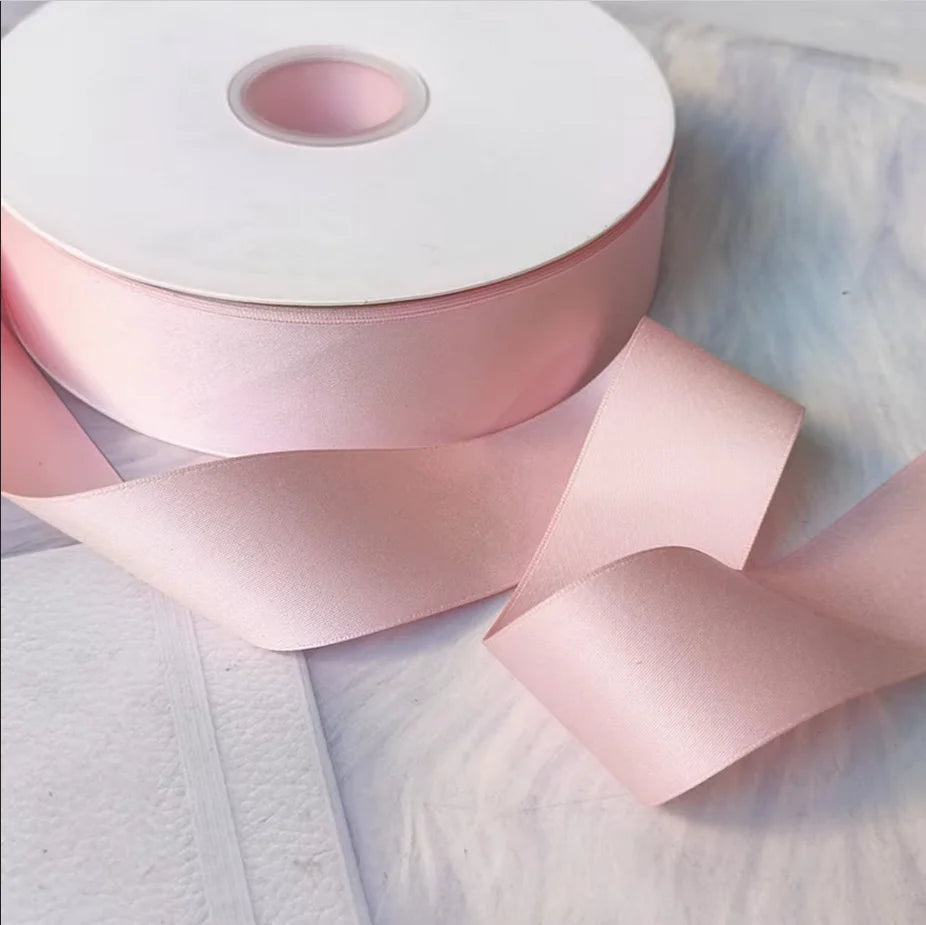 Roll of matte finish pink satin ribbon for crafts, wrapping, and decor