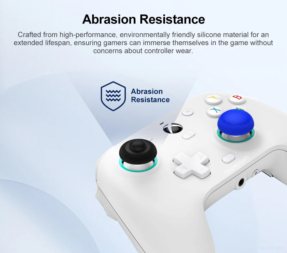 A close-up of a white gamepad showing blue silicone thumb grips designed for improved abrasion resistance.