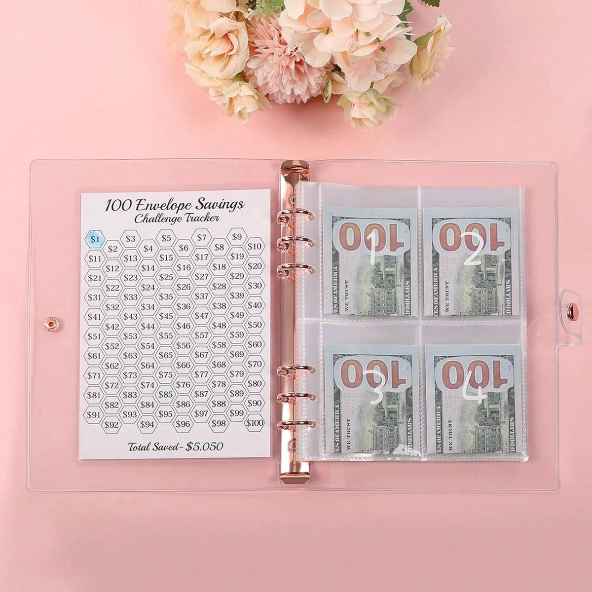 A clear plastic envelope tracker showing 100 envelopes for savings challenges with US currency.