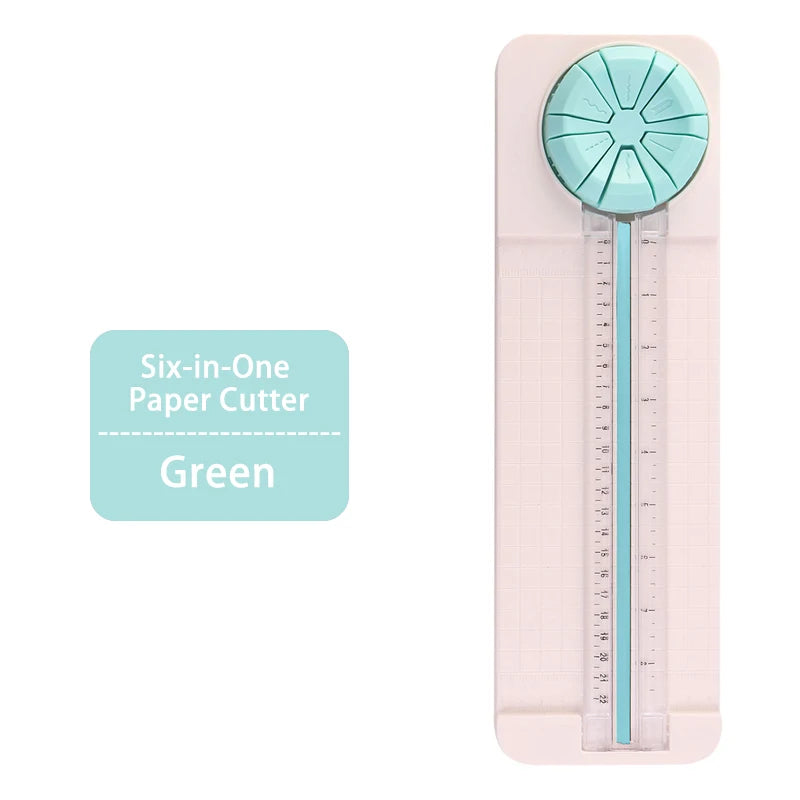 A pink six-in-one paper cutter with a light blue rotary blade and a clear ruler scale.