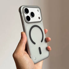 Une main tient une coque magnétique fine pour iPhone Magsafe avec un dos transparent et le module caméra.