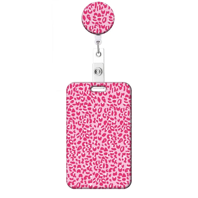 A pink leopard print retractable badge holder with a circular top.
