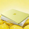 A yellow Apple MacBook Neo laptop is shown in a protective case surrounded by golden spheres.