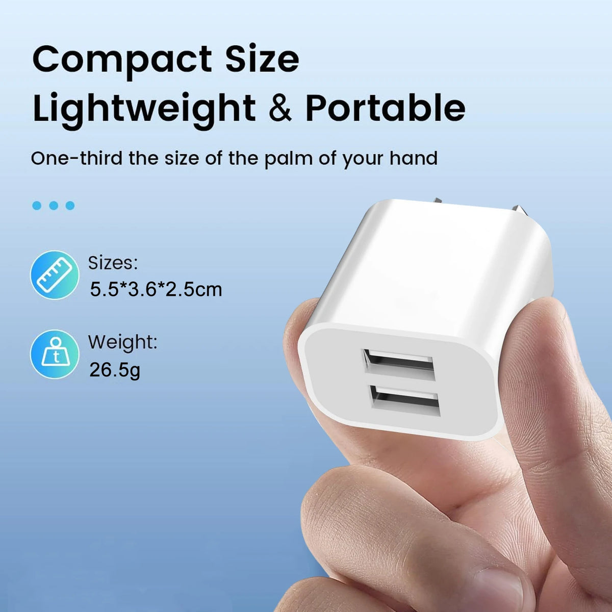A hand holds a white compact lightweight portable dual port wall charger with USB ports.