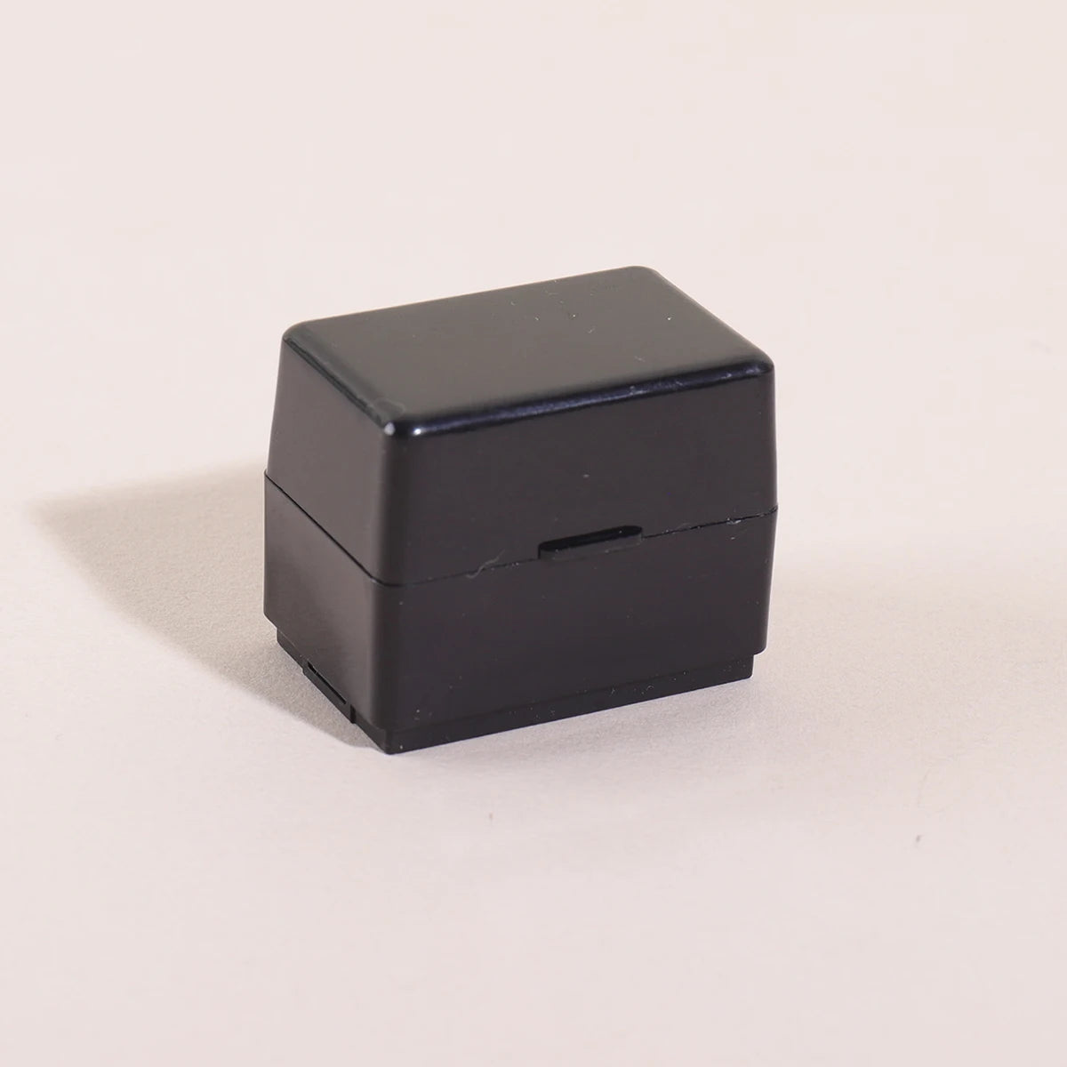 A black privacy protection roller stamp is shown from the top view against a light background.