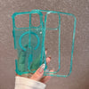 A clear teal shockproof magnetic case with a glitter finish for an iPhone is held in a hand.