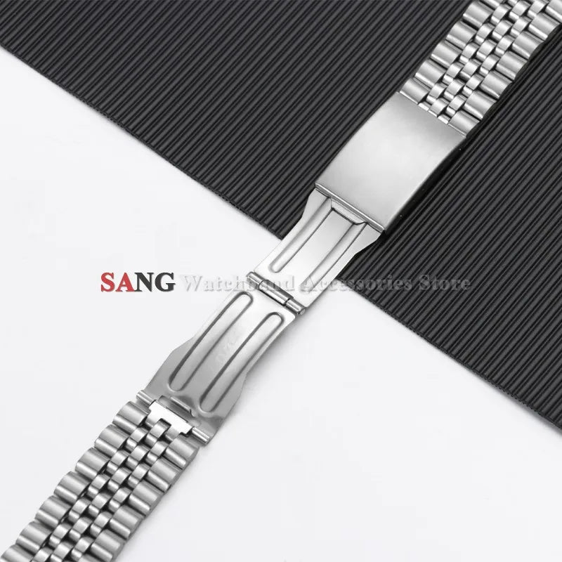 A close-up view of a polished stainless steel watch band with a textured surface and folding clasp.