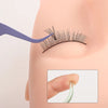 A purple precision tweezer is used to apply lash extensions or nail art on a person's eyelid.