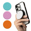 A hand holds a smartphone with a silicone ripple grip and magnetic stand components in various colors.