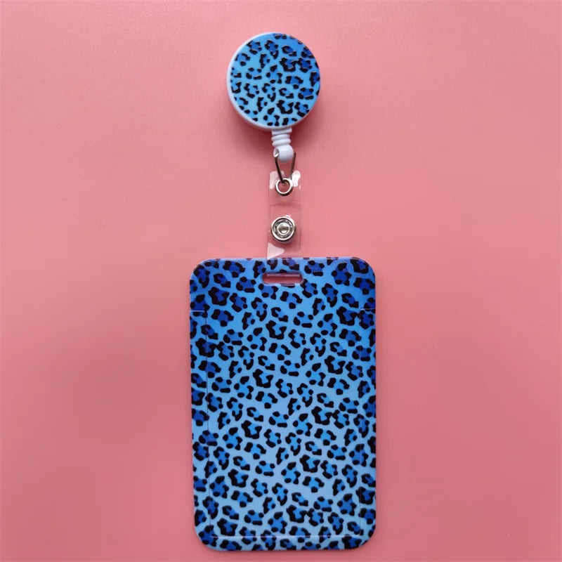 A blue leopard print retractable card holder clip with a circular badge holder attached.