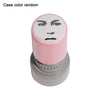 A pink rubber stamp with a funny meme face design on the top and a silver base.