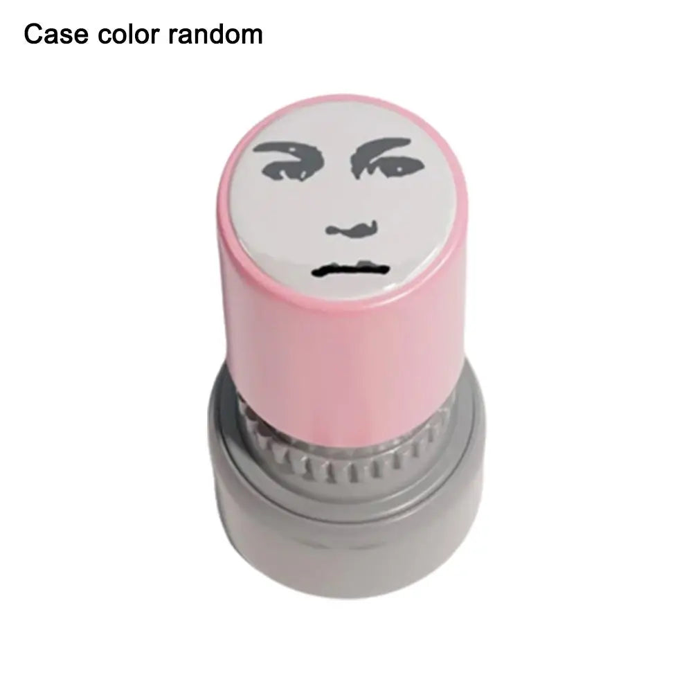 A pink rubber stamp with a funny meme face design on the top and a silver base.