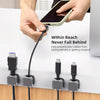 Hands are using a cable to connect a device, demonstrating magnetic cable management clips for desks and walls.