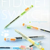 A set of color changing fidget pens shown in various orientations and colors against a light blue background.