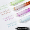 A collection of assorted colored retractable erasable gel pens lying on a white surface.