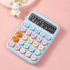 A light blue mechanical 12-digit calculator with round keys is shown on a pink background next to a small white bear figurine
