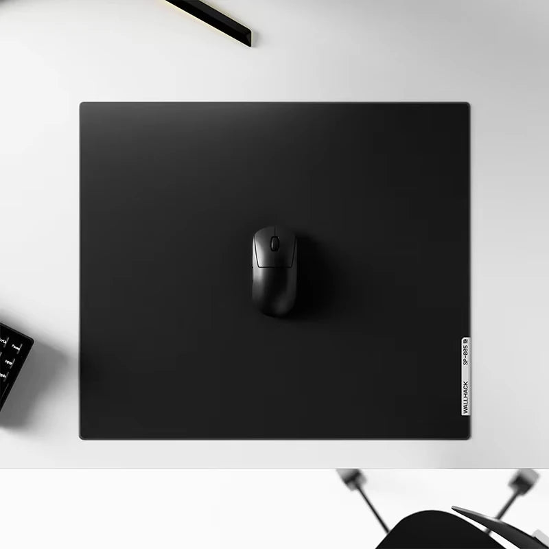 Un tapis de souris en verre trempé noir avec une seule souris de jeu noire posée dessus.