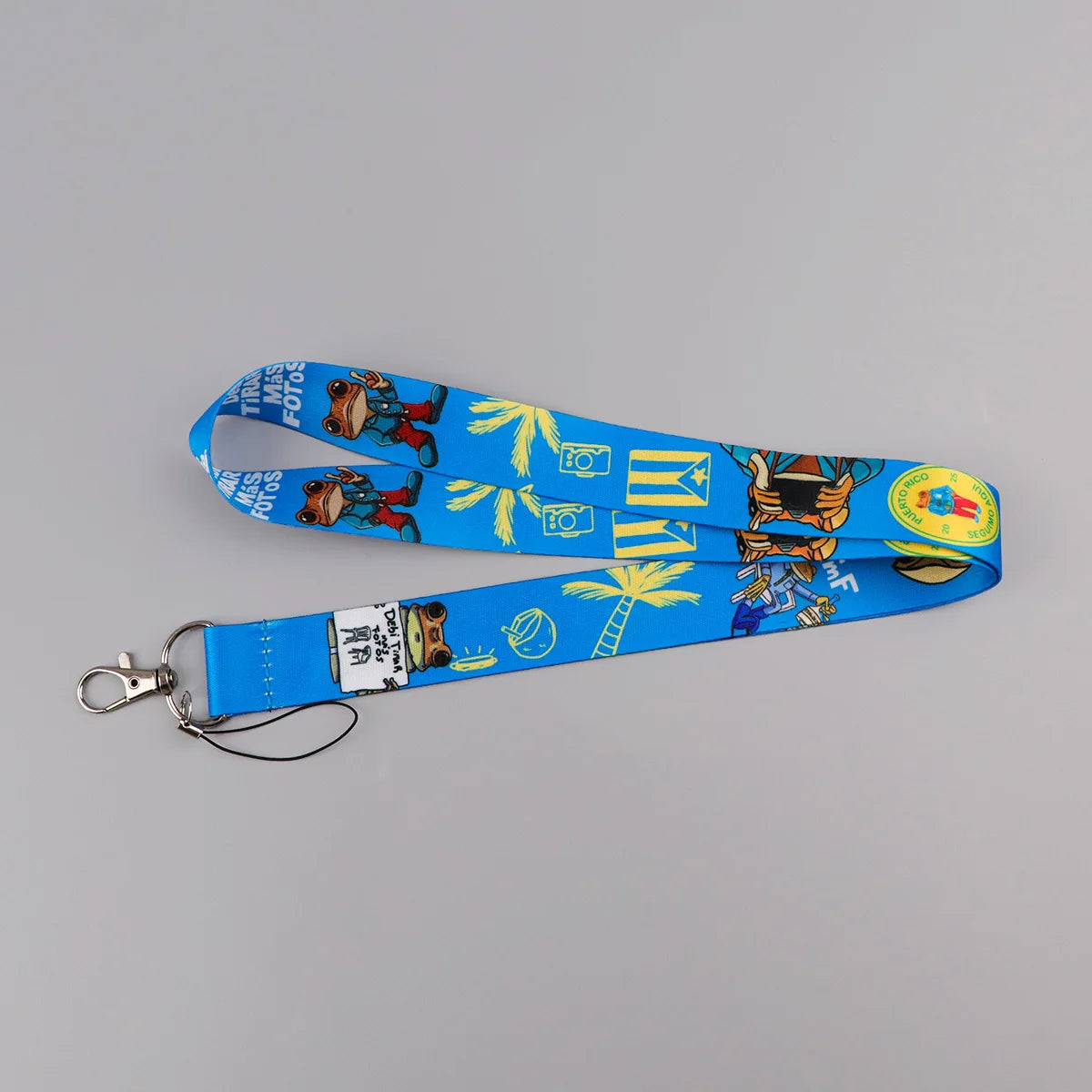 Blue lanyard featuring a repeating pattern of cute cats, palm leaves, and camera icons.