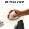 A hand is holding a white ergonomic vertical wireless mouse above a light-colored surface.