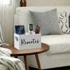 A white wooden storage box with dividers is placed on a bedside table next to a white sofa.