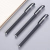 A pack of three black gel ink pens with silver accents lying on a light gray surface.