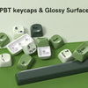 A collection of bright green PBT keycaps, including PgDn, Esc, Num, and Shift keys, displayed on a green surface.