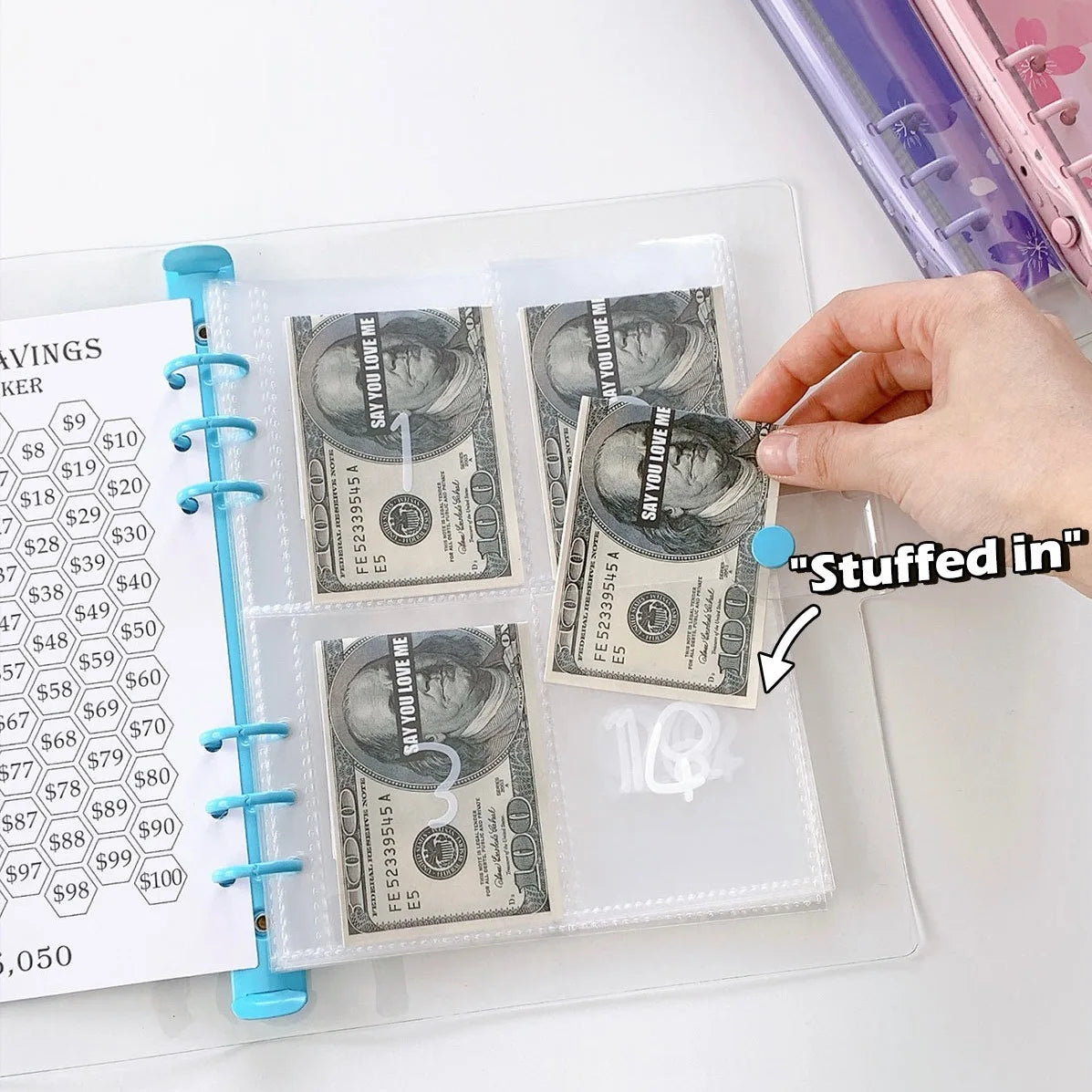A clear plastic sleeve holds several sheets of money and a planner page with a hand stuffing a bill into the sleeve.
