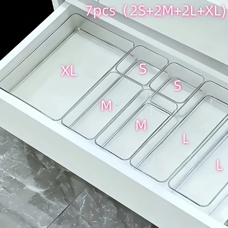 A white acrylic drawer organizer set with seven compartments labeled XL, S, M, L, and others.