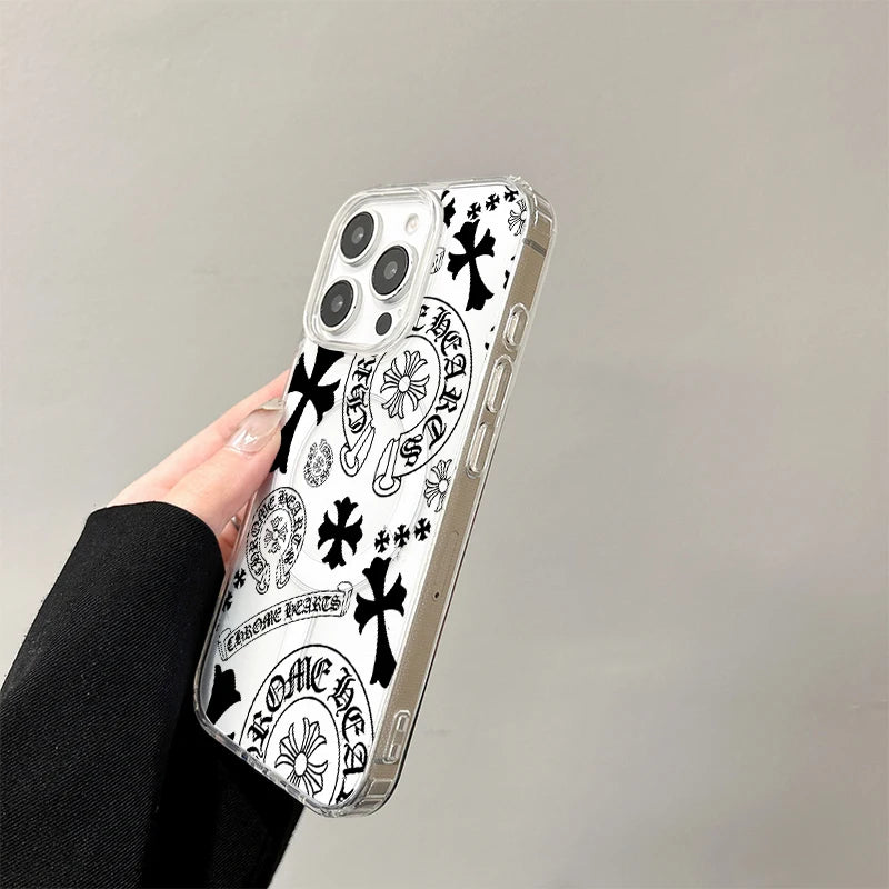A clear acrylic phone case featuring a black and white design with Chrome Hearts motifs, held by a hand.