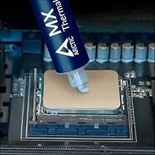 Tube of MX Arctic thermal paste positioned on a circuit board for CPU or GPU cooling.