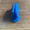 A bright blue silicone self-adhesive pen holder with two prongs resting on a wooden surface.