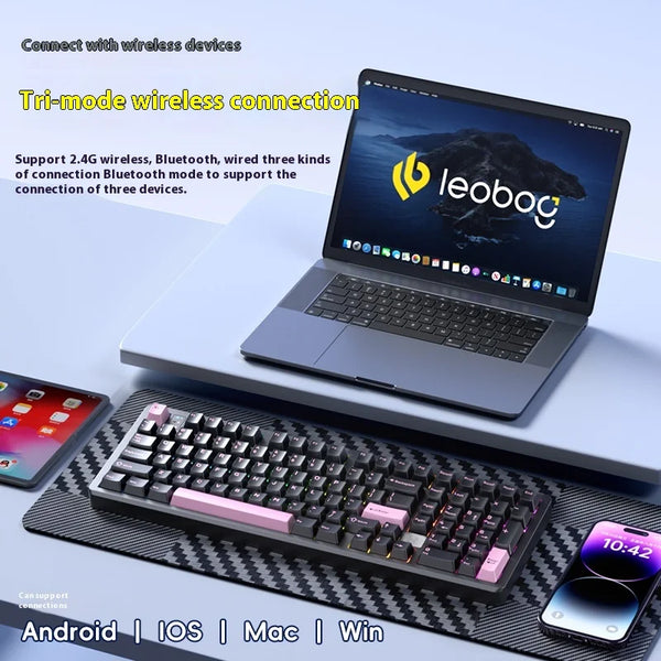 A laptop is shown next to a mechanical Bluetooth wireless keyboard and a smartphone, demonstrating tri-mode wireless connecti