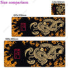 A black gaming desk mat featuring an orange and gold Japanese dragon design.