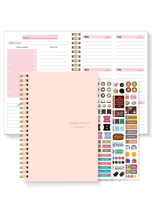 A pink A5 weekly planner spiral notebook with monthly layouts and habit tracker pages.