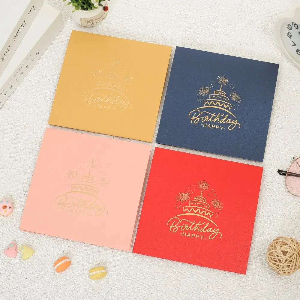 A set of three rectangular birthday greeting cards in yellow, blue, and red with gold foil designs.