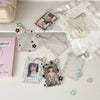 Collection de porte-photos en acrylique et pendentifs avec divers charms disposés sur une surface blanche.
