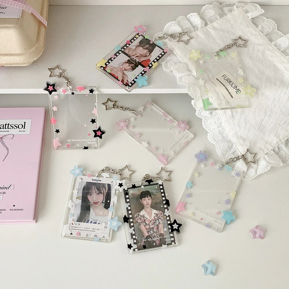 Collection de porte-photos en acrylique et pendentifs avec divers charms disposés sur une surface blanche.