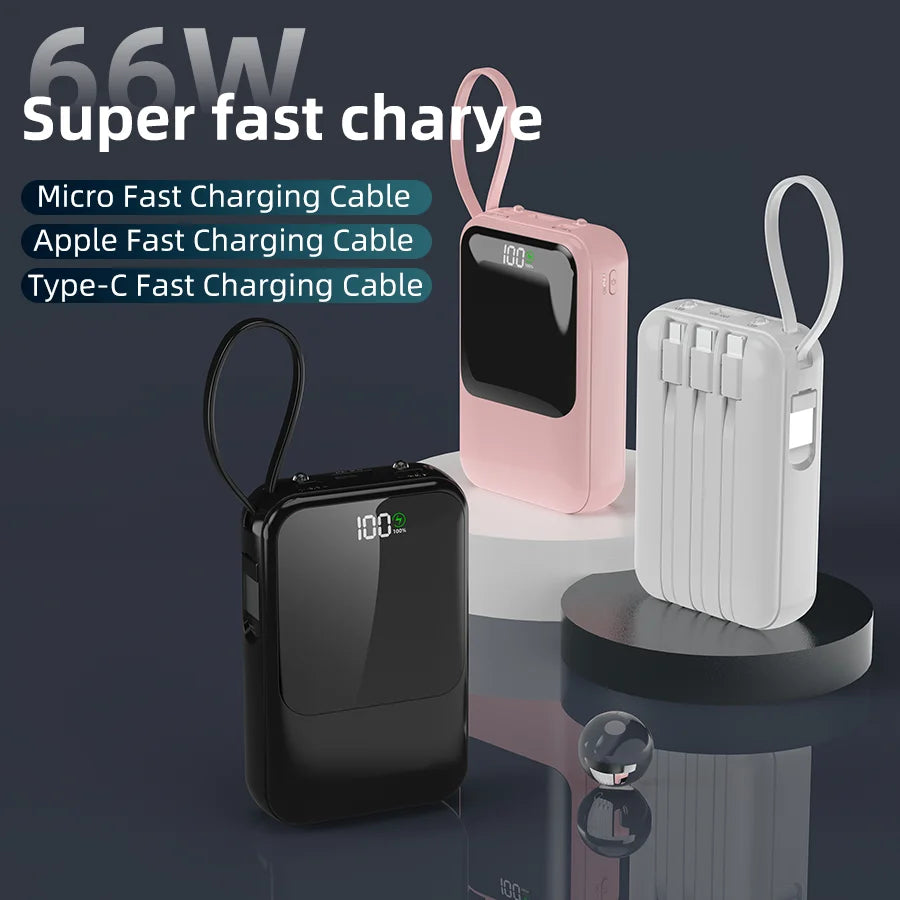 Batterie portable rose et noire avec divers câbles de charge sur une surface sombre.