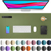 A large green desk mat featuring various color swatches and a computer monitor, keyboard, mouse, and smartphone.
