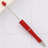 A red DIY beadable pen with a silver tip and a red cap resting on a white surface.