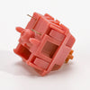 A close-up view of a pink rosewood linear mechanical keyboard switch housing.