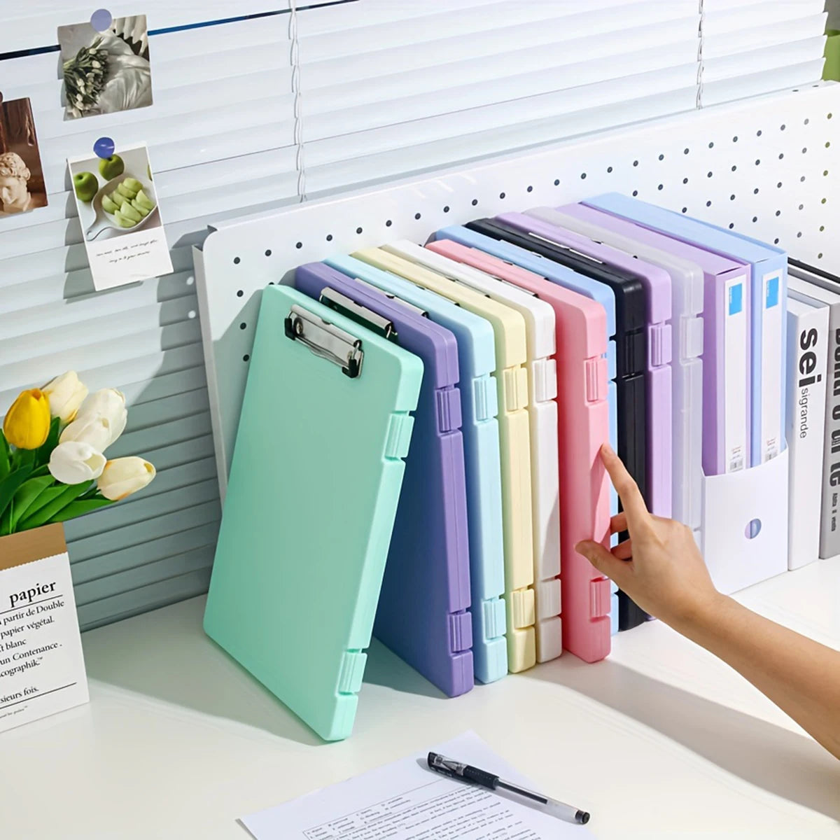 A collection of colorful A4 document and photo storage file boxes lined up on a white desk.