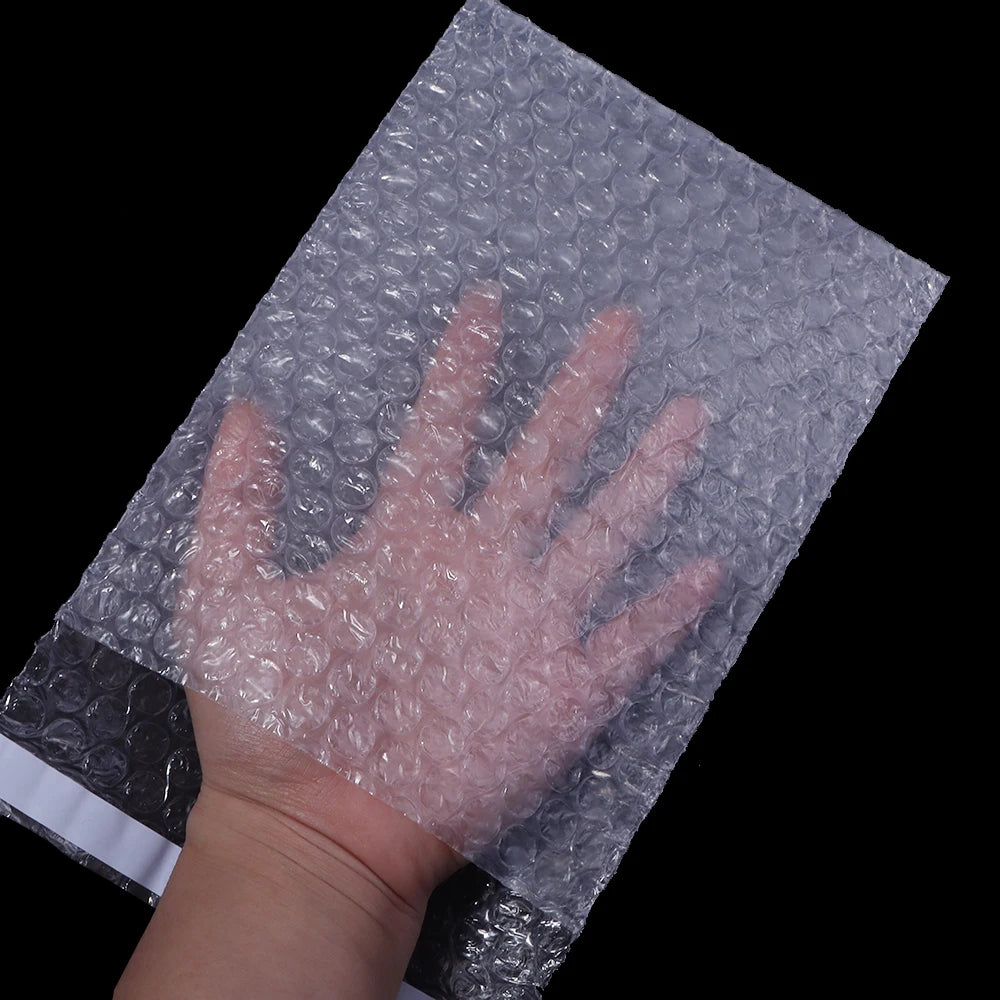 Eine Hand drückt eine klare, selbstversiegelnde Schaumverpackung auf eine dunkle Oberfläche.