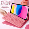 A pink detachable keyboard is shown resting on a matching pink protective case next to a tablet.