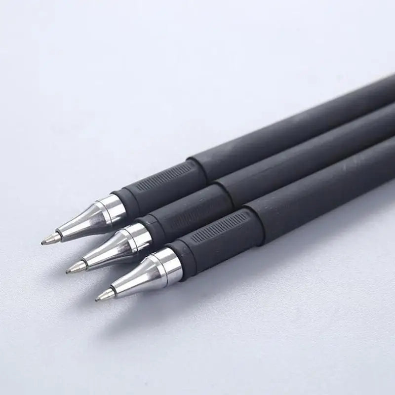 A close-up view of a bulk pack of black gel ink pens with silver tips lying on a white surface.