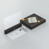 A black box containing a rechargeable acrylic book night light with a timer and charging cable.