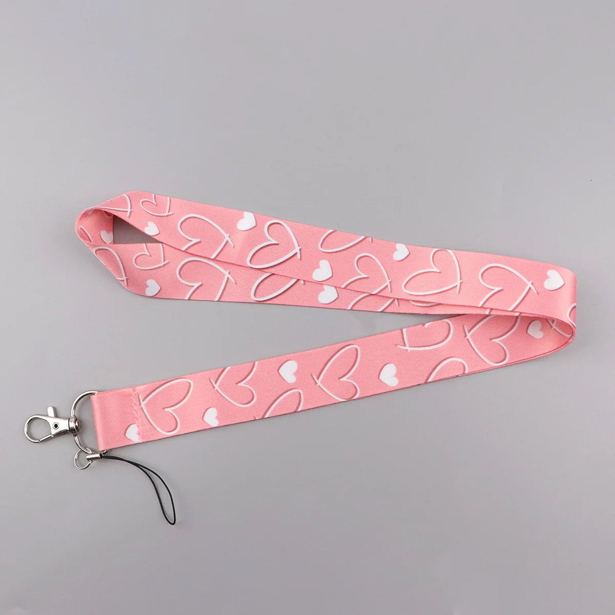 Pink heart-shaped lanyard strap with a repeating pattern for badges and keys