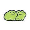 A pair of lime green enamel pins shaped like smiling frogs.