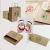 Various mockups of custom self-inking stamps with logos and text on kraft paper and packaging boxes.