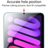 A close-up of a transparent screen protector being applied to an iPad screen, showing precise hole positioning.
